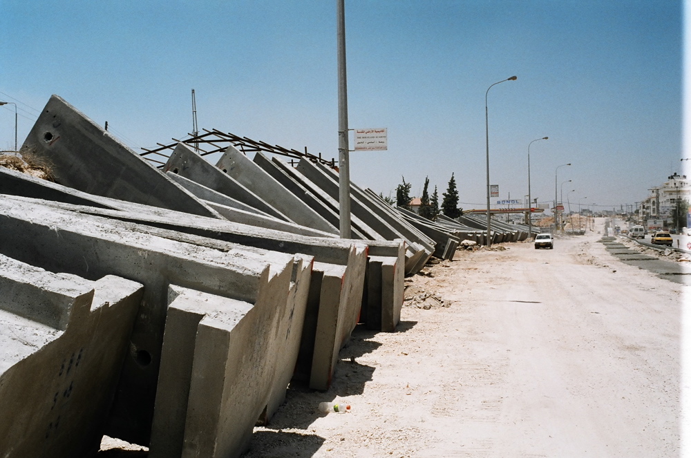 Concrete blocks of 4.5 meter high lying on the road in preparation of the construction of the 2.2 km Barrier Wall from Ar Ram checkpoint until Qalandiya checkpoint. June 2004 Ar Ram, Feb. 04 01.jpg