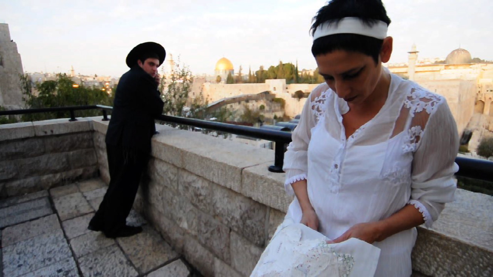 Sewing 'Jerusalem Wounded Map' by the Wailing Wall, still by Yair Tsriker from the video: The Green Thread, Dada-Jerusalem 027