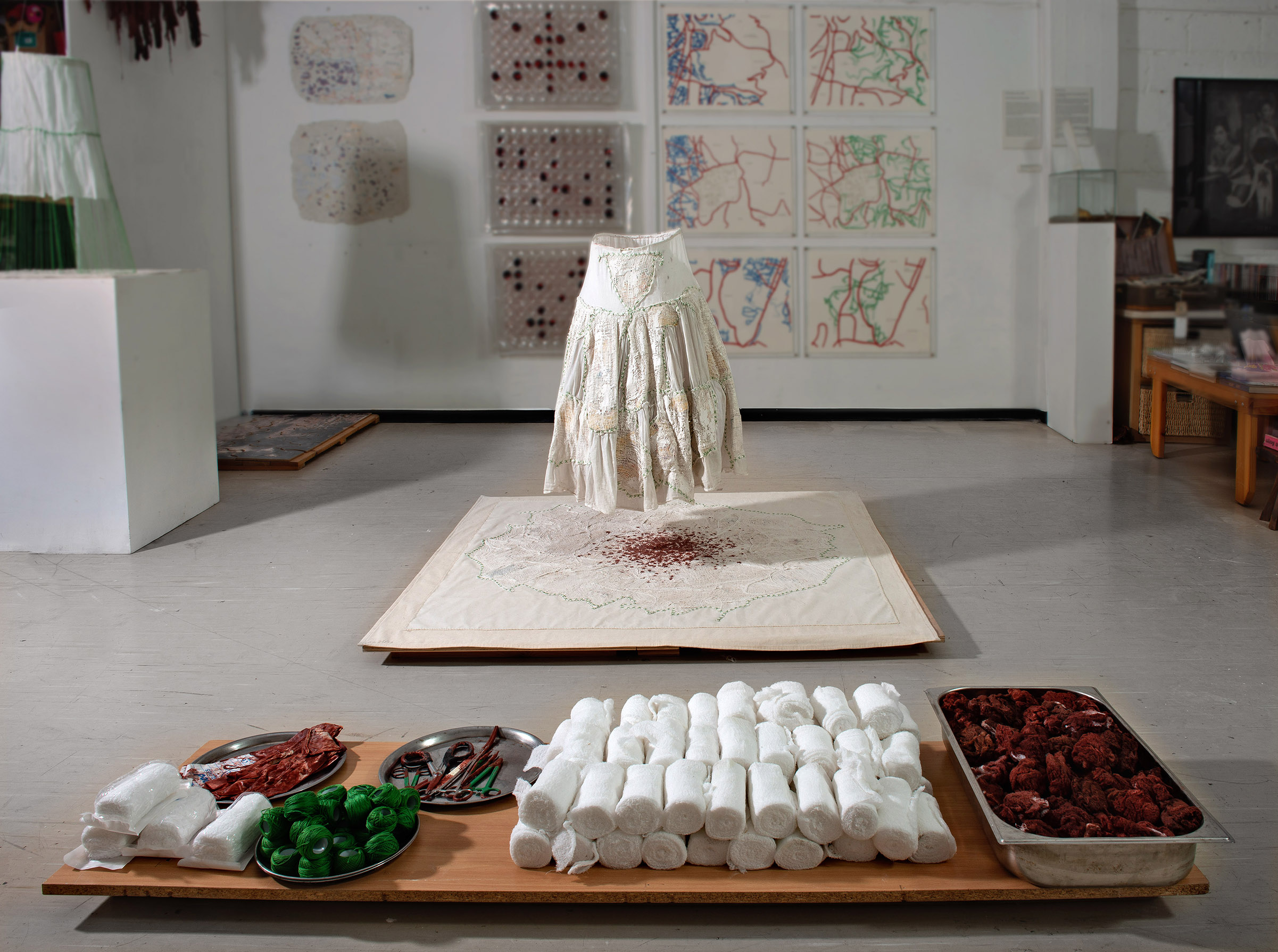 Installation in the studio in Jerusalem, fabric, maps, gauzes bandages, plaster, wax, earth, pigments, green spools with pan, bandages, haemostats, sterilized gloves and scissors, photo: Michael Amar Dressed Land 2012 01