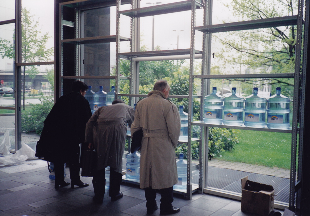 Putting up the water container on the specially built shelves in the shape of a cross Dusseldorf 04