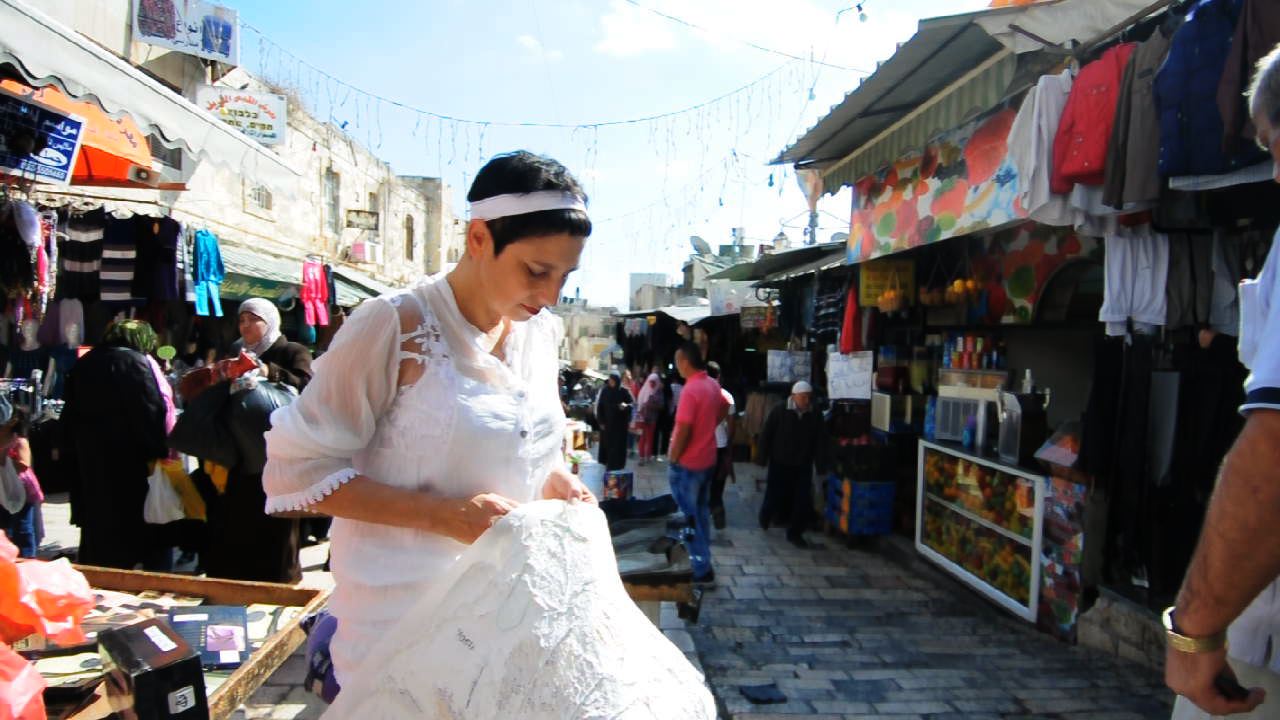 The Green Thread 2011, Sewing a wounded map of Jerusalem beside the Damascus Gate in The Arab market Photo: Yair Tsriker Green Thread 002