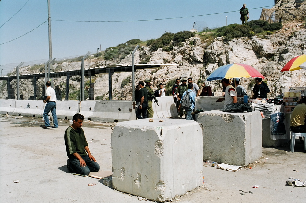 Man praying near the Kalandiya checkpoint, April 2004 Qalandiya Checkpoint, Apr.04 01
