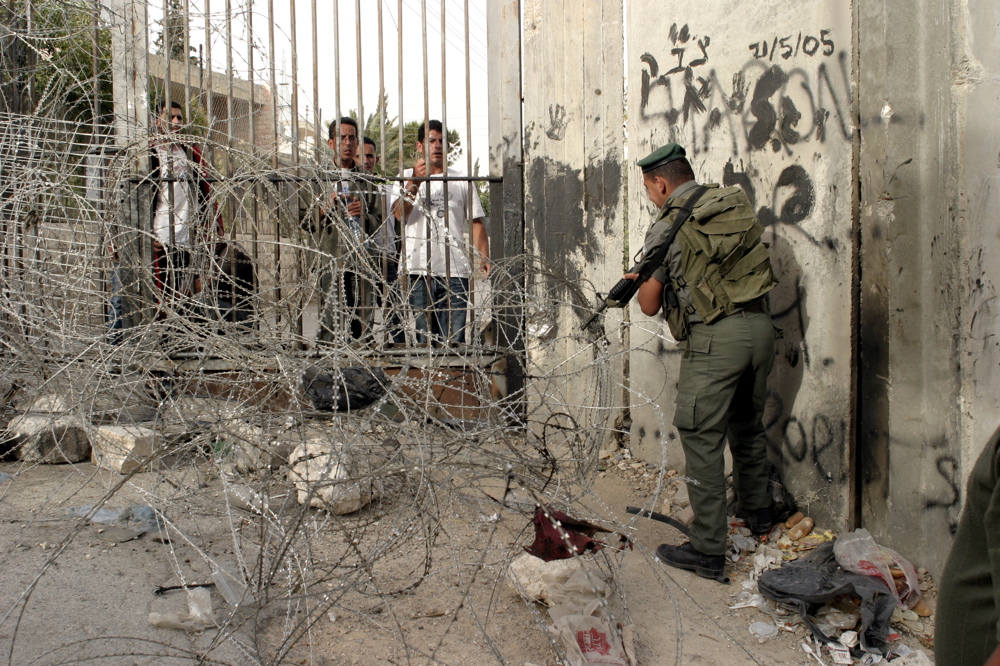Soldier closing a barbed fences in Abu Dis to prevent Palestinians men from Al-Azhariya to cross over to Abu Dis, June 2005 Soldier closing fence, Abu Dis June 07 05 03
