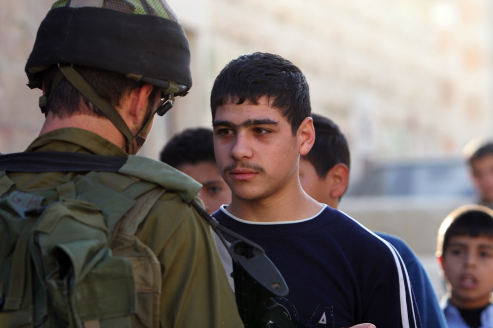 Young Palestinian and IDF soldier at a checkpoint in Hebron, September 2005 Young Palestinian and soldier, Hebron, 29.11.05 03